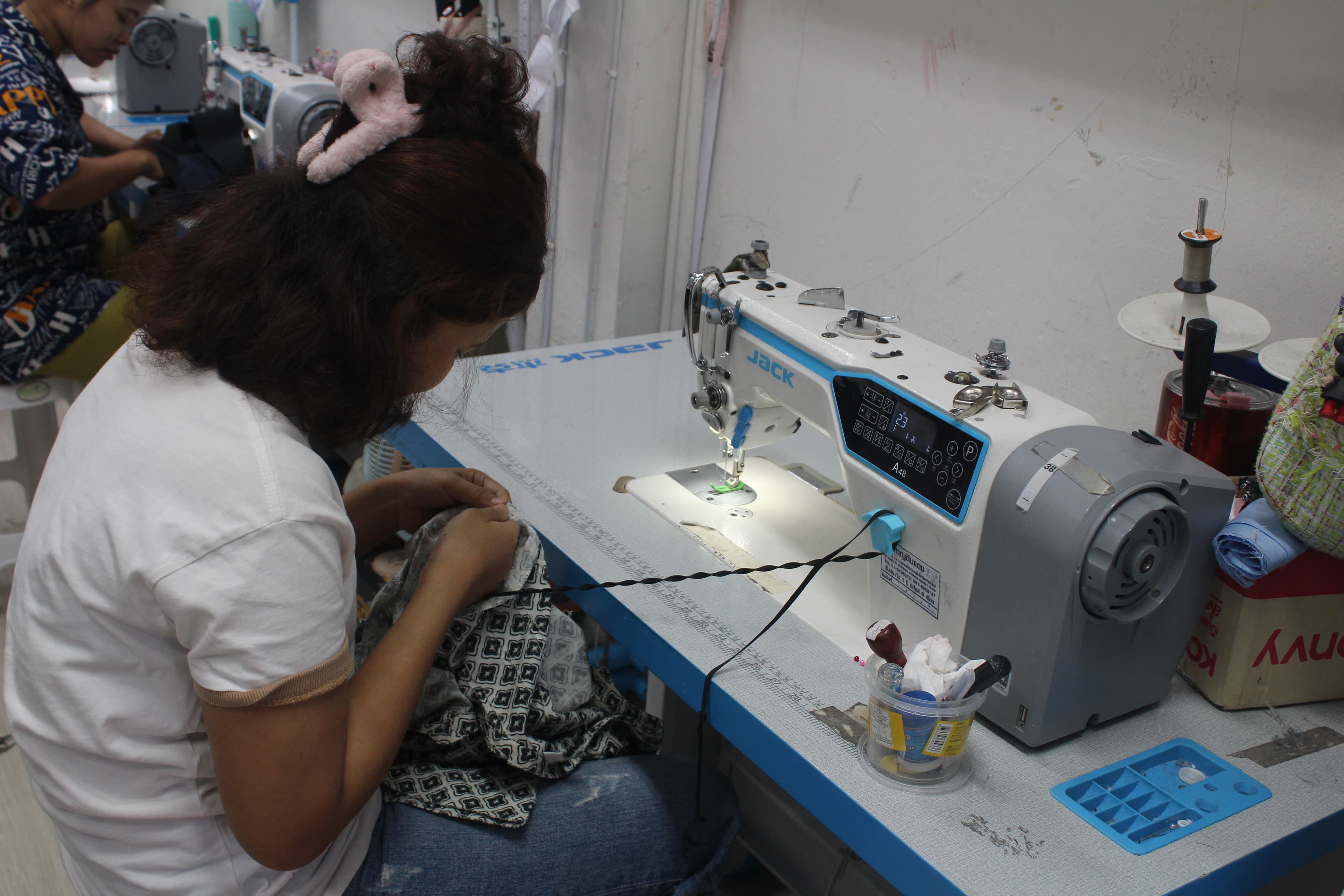Hands cutting a paper sewing pattern with shears
